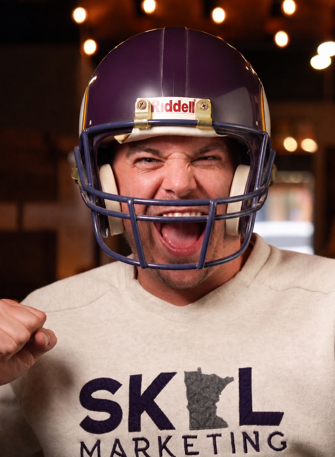 Very excited man in a MN Vikings helmet cheering.